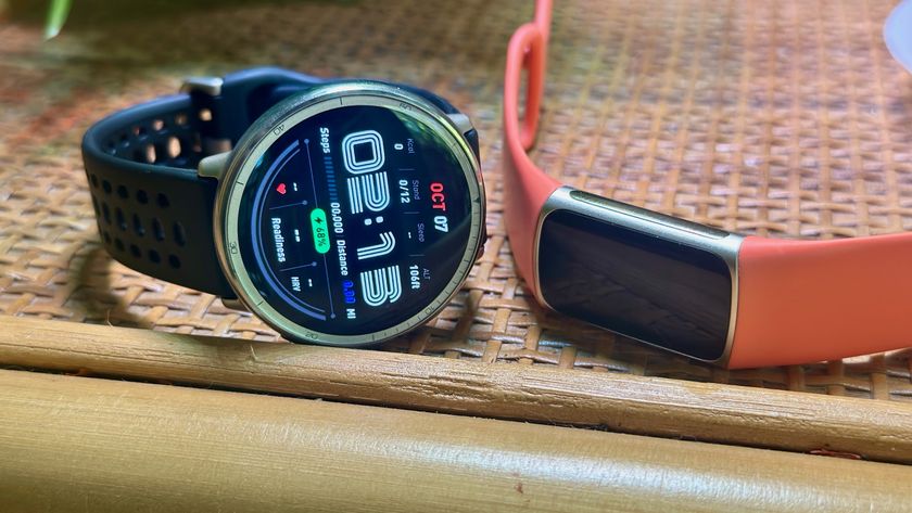 An Amazfit Active 2 fitness watch (left) and Fitbit Charge 6 fitness band (right) sitting on a wooden shelf.