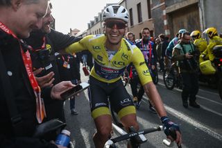 Soudal Quick-Step's Belgian rider Tim Merlier (C) wearing the overall leader's yellow jersey celebrates after crossing the finish line to win the 2nd stage of the Paris-Nice cycling race, 183,9 km between Montesson and Bellegarde, on March 10, 2025. (Photo by Anne-Christine POUJOULAT / AFP)