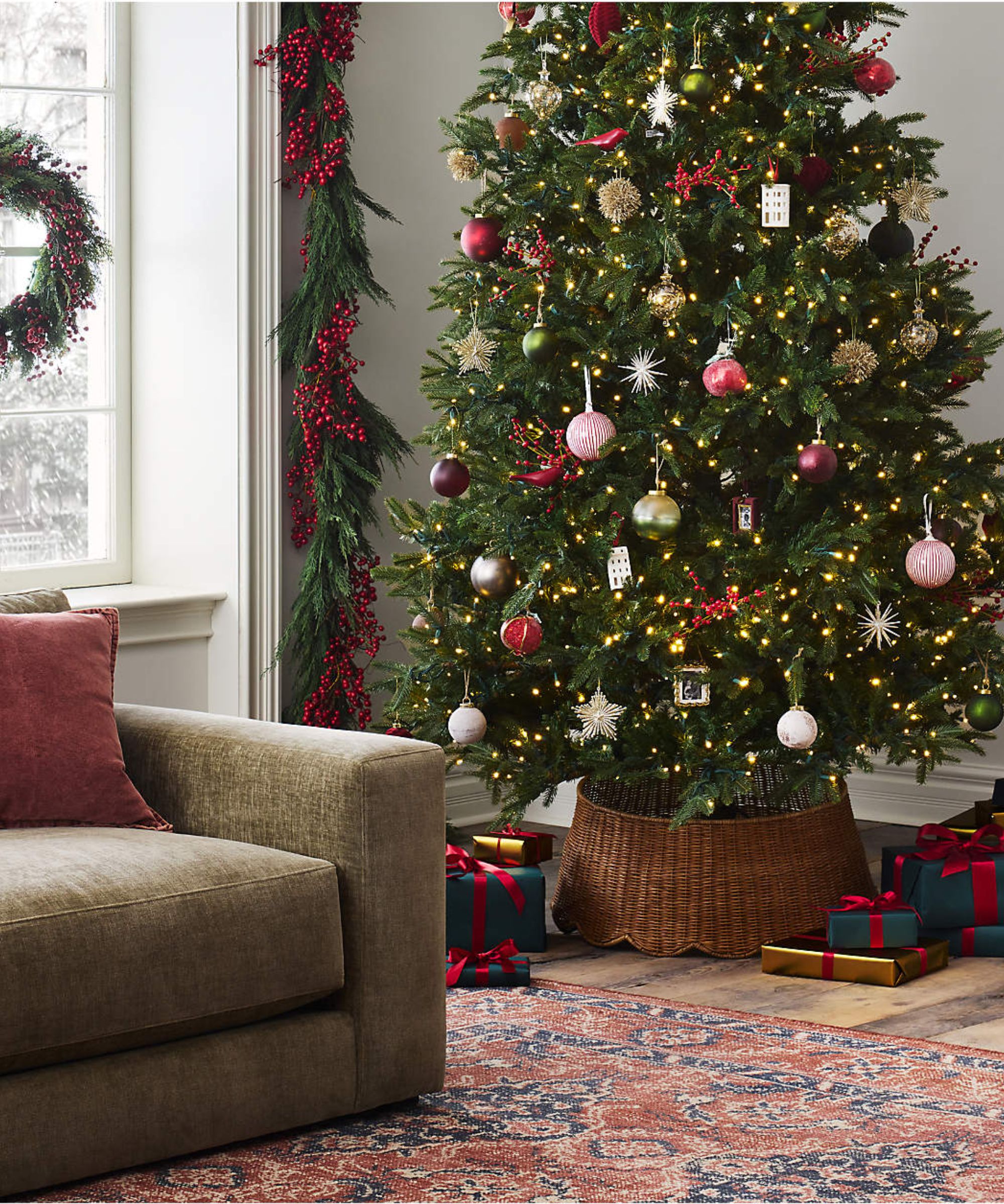 a living room with a christmas tree decorated with colorful ornaments and presents underneath