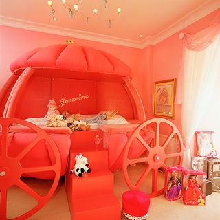 kids bedroom with pink carriage bed and pink wall