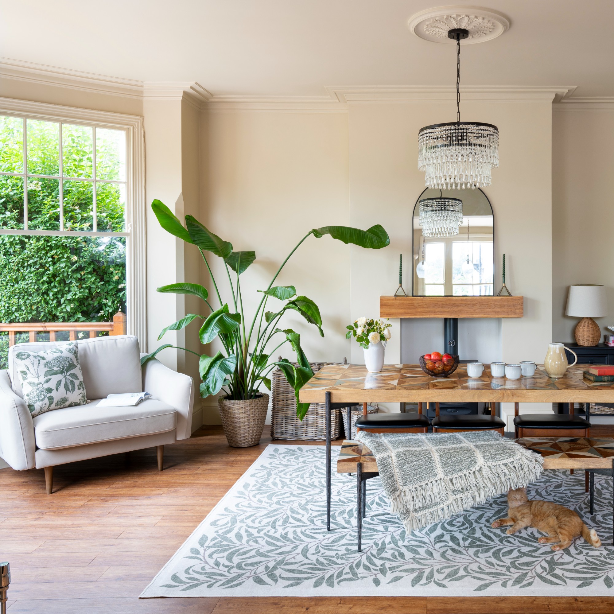 A dining area with a bench and three chairs at a rectangular dining table with a grey armchair to the side