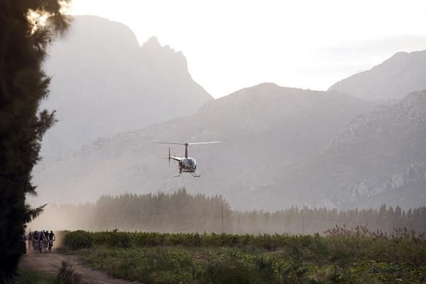A helicopter hovers over the lead bunch during stage four of the Cape Epic