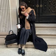 Influencer wearing a faux fur scarf, jeans, and loafers