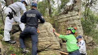 NSW ambulance crews work to save woman trapped between boulders