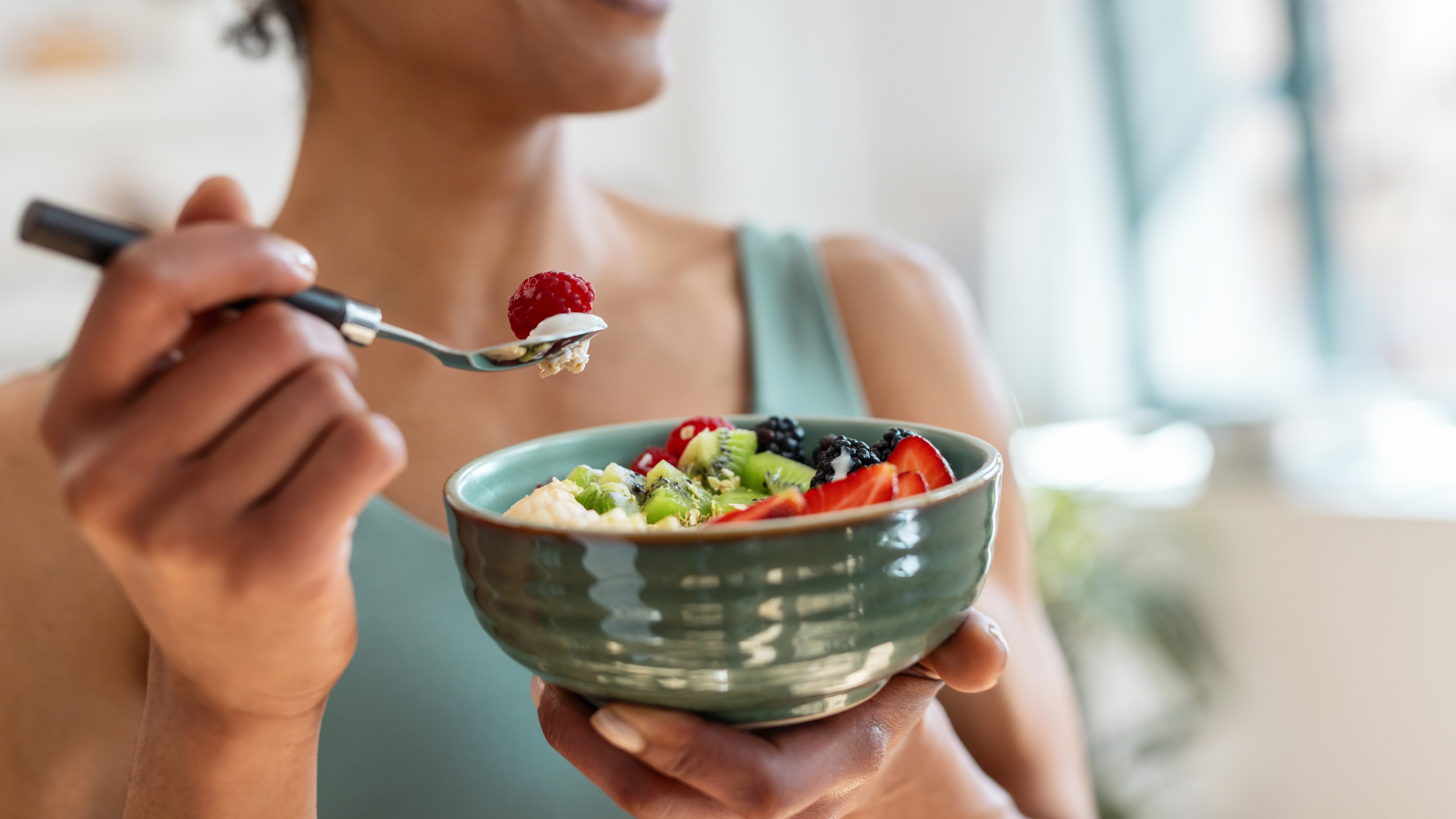 a woman eating a fruit bowl