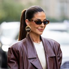 street style shot of woman with glossy lips with a high pony tail