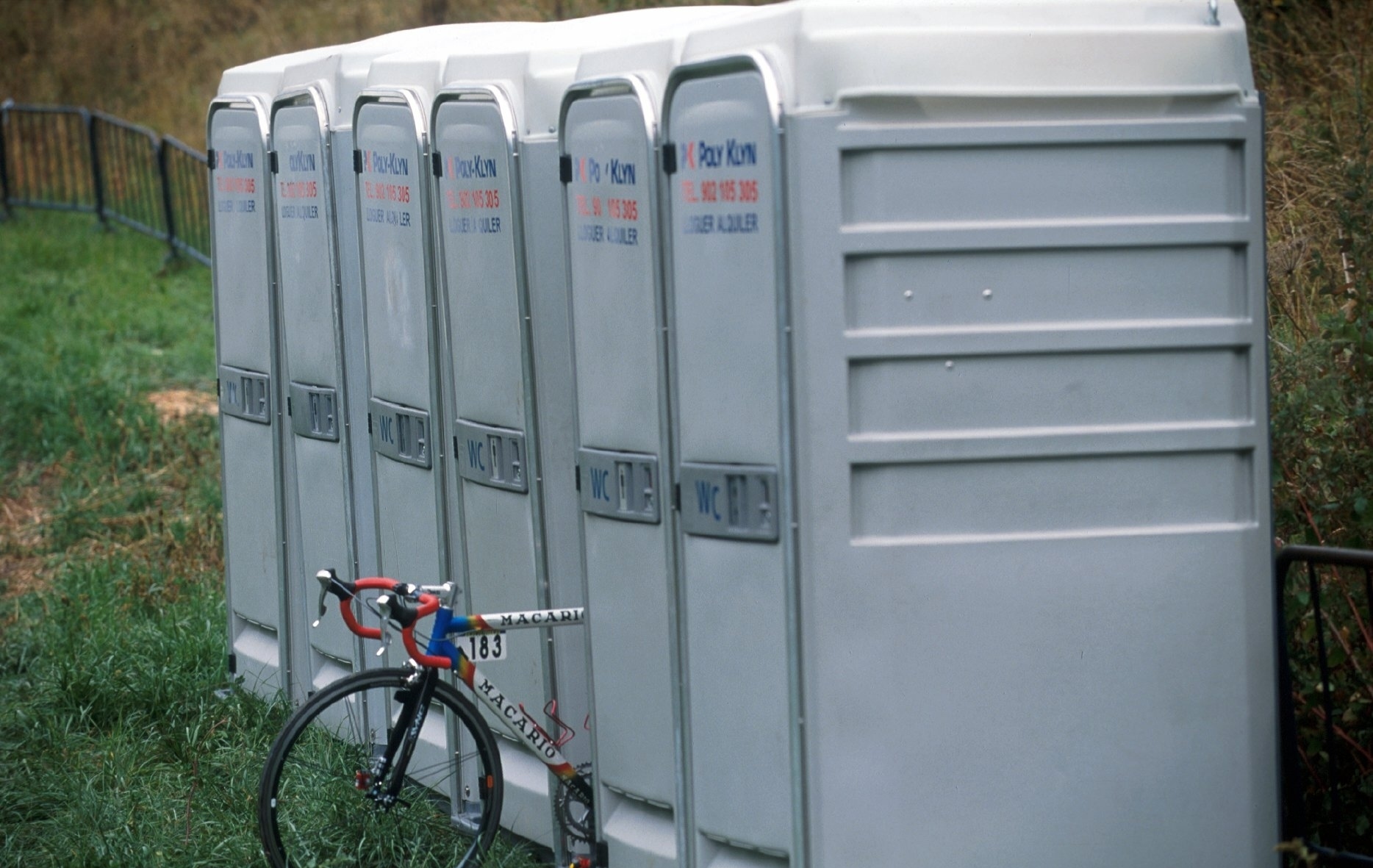 A bike sits between portaloos at the Vuleta in 2001