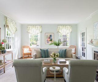 living room with pale green walls, two armchairs and one sofa near fireplace