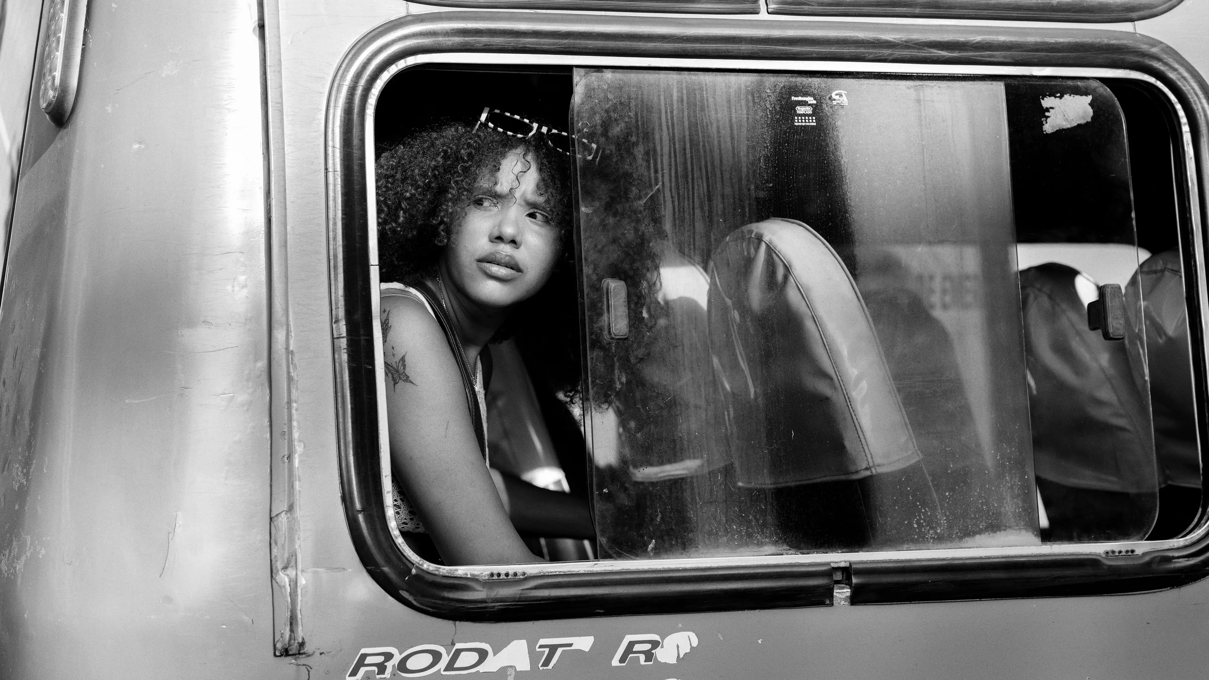 Young woman looks out of bus window.