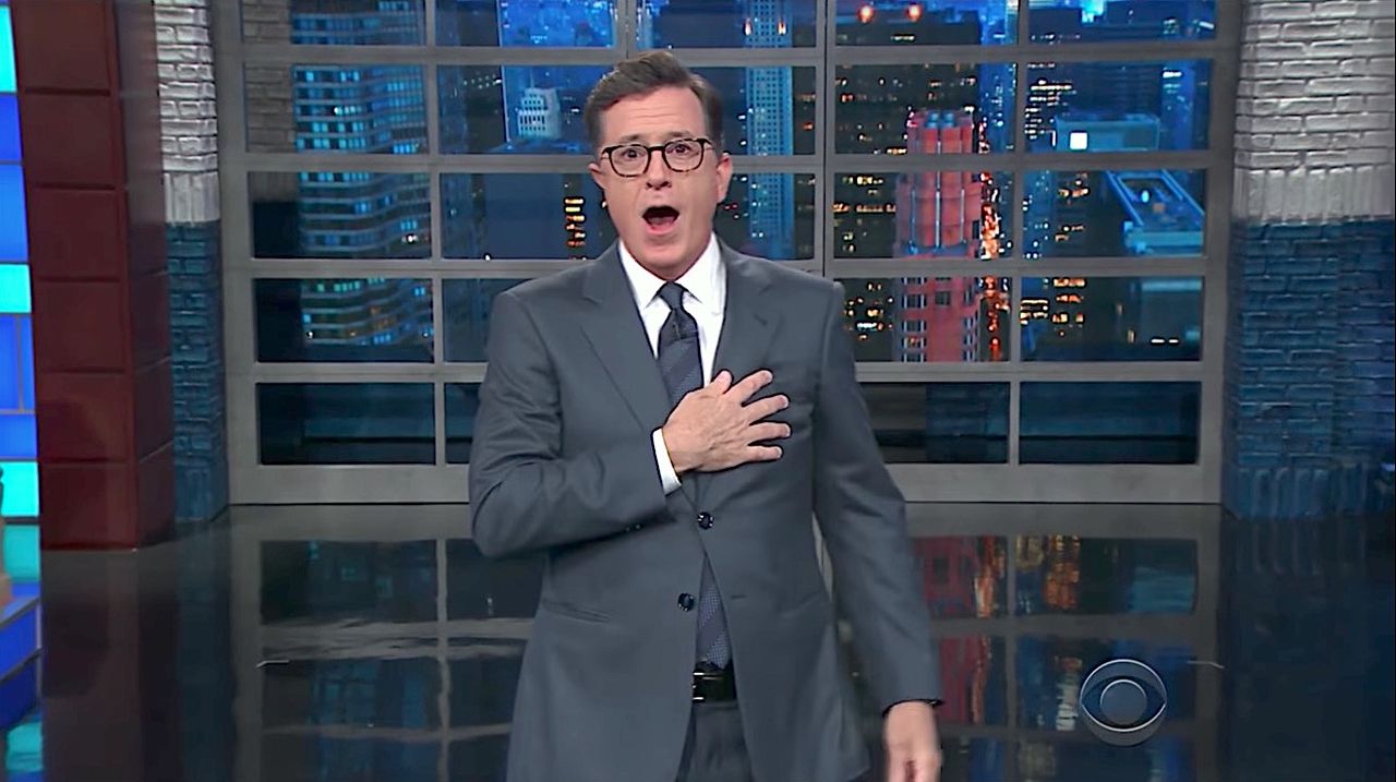 Stephen Colbert throws a flag