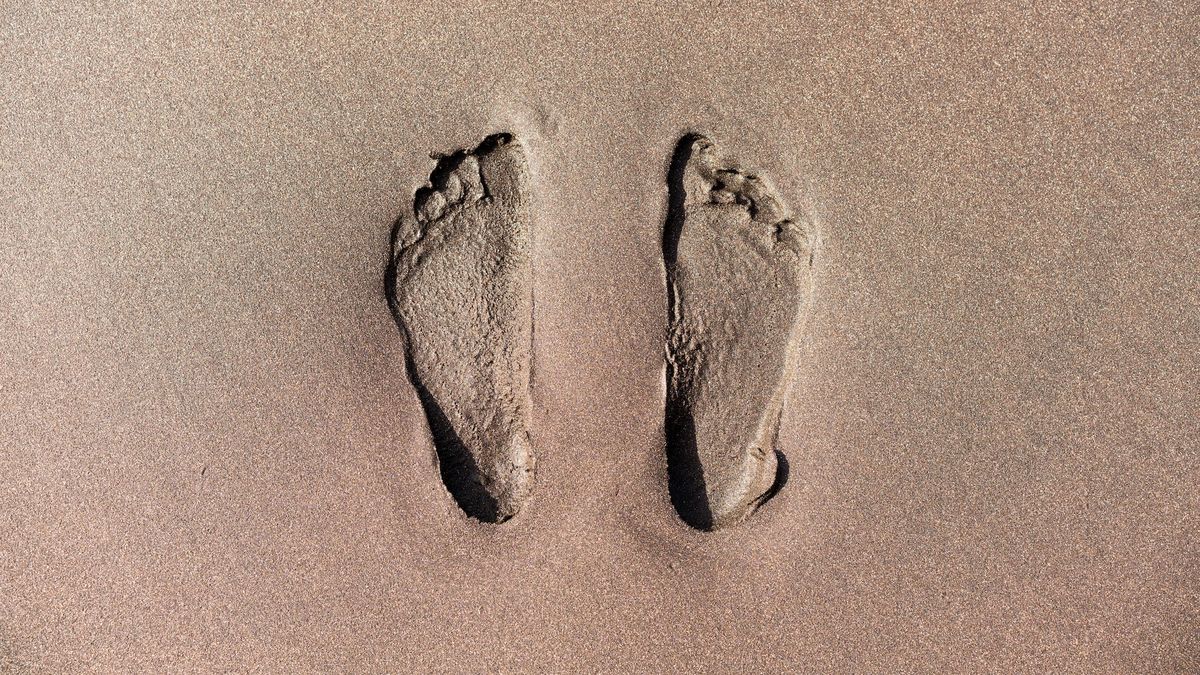 An image of two human footprints in the sand
