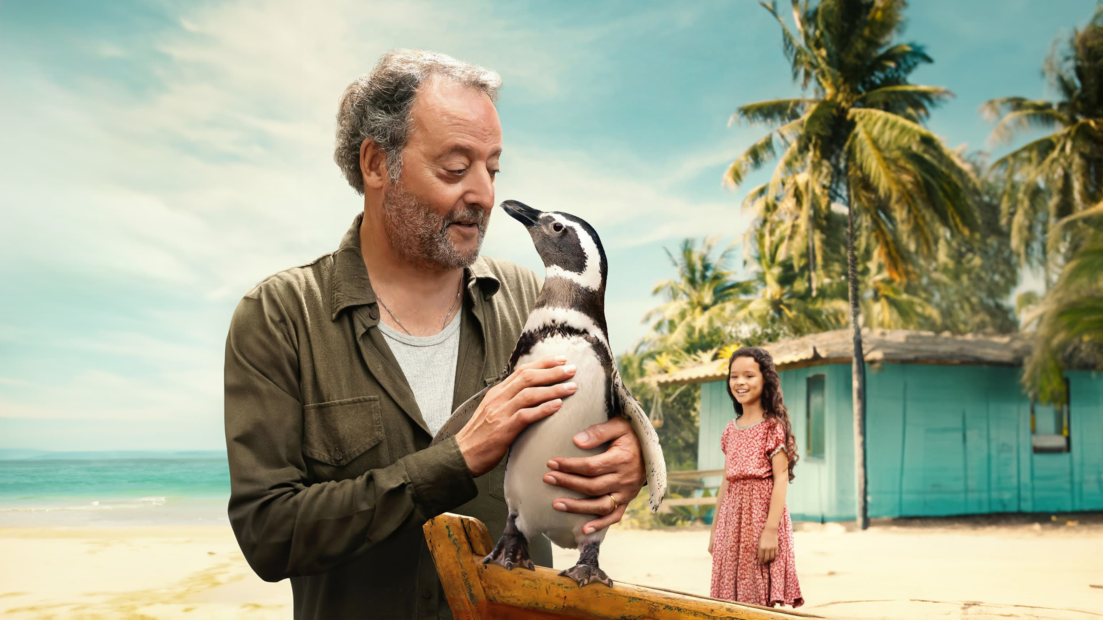 A promo shot for the movie My Penguin Friend of Jean Reno as João Pereira de Souza holding a penguin