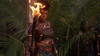 Viola Davis as Nanisca holding a torch in The Woman King