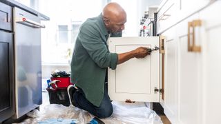 man fitting new kitchen cabinet doors