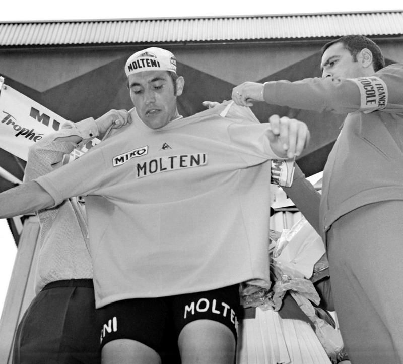Eddy Merckx gets some help to pull on the first yellow jersey of the 1971 Tour de France in Mulhouse. He won the race for a third time that year