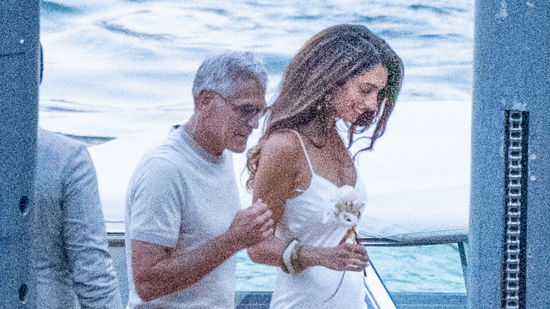 An image of Amal Clooney in Lake Como wearing a white slip dress and silver heels. 