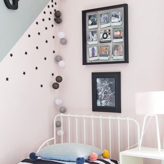 Pink and grey bedroom with black photo frame