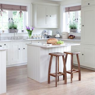 kitchen with island unit and wooden floor and two stools