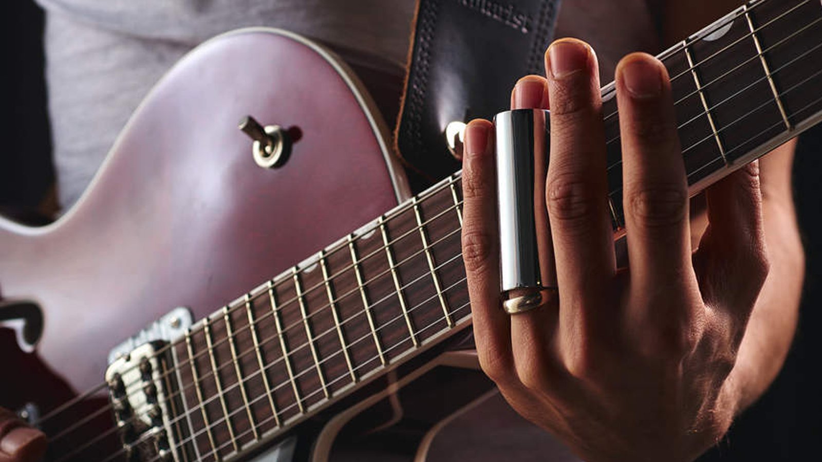 Man playing Gretsch guitar with a slide