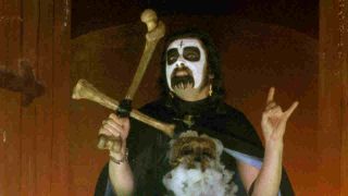 King Diamond posing for a photograph in make-up with a crucifix in 1983