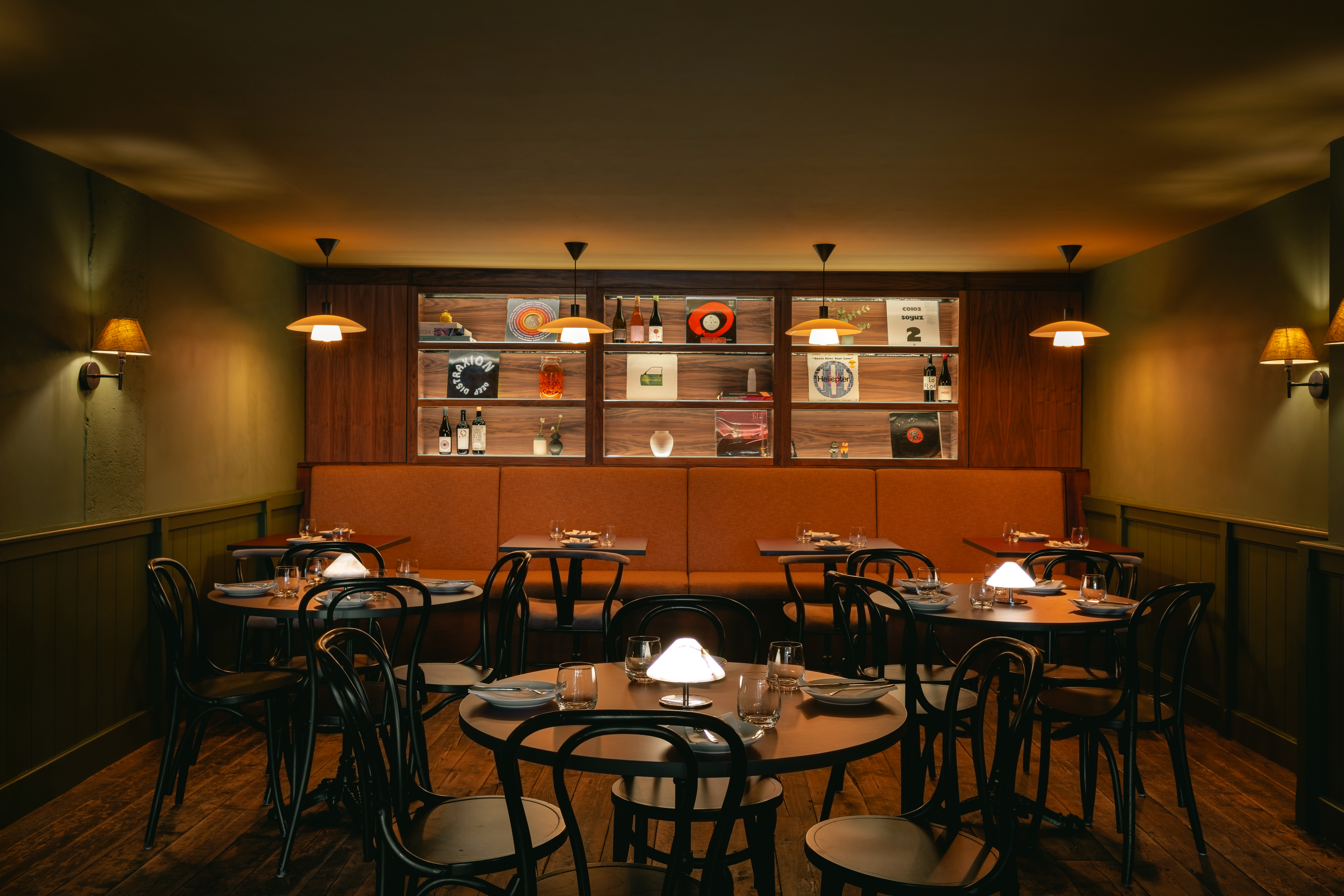 an image of the interiors of Sova showing three small round tables and the banquette