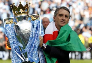 Manchester City manager Roberto Mancini carries the Premier League trophy, 2012