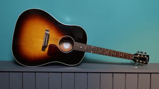 Gibson J-45 against a blue wall in our photo studio