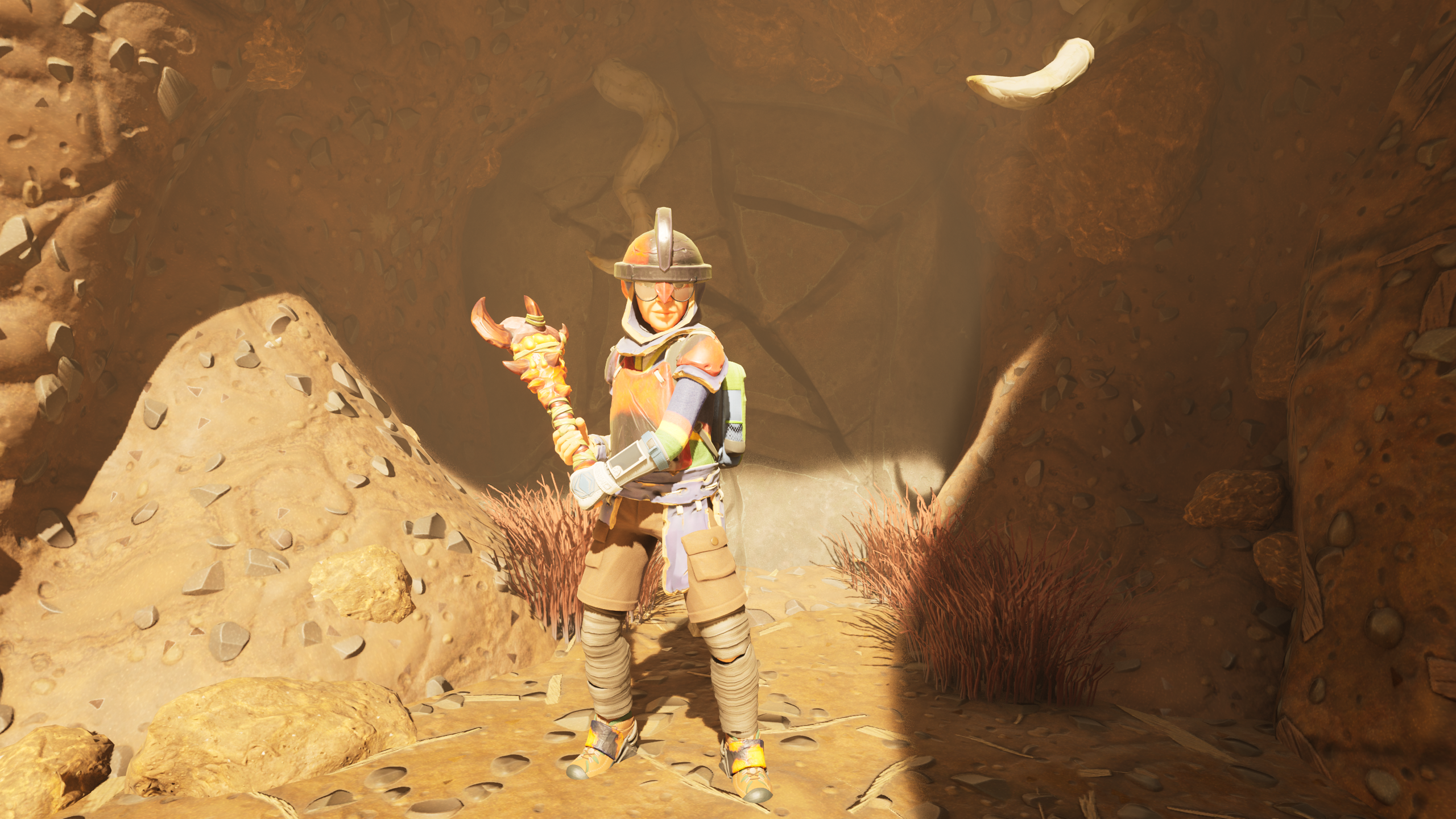 Grounded 2 cracked rocks explosives: A character standing outside a cave blocked by cracked rocks, holding a club at the ready.