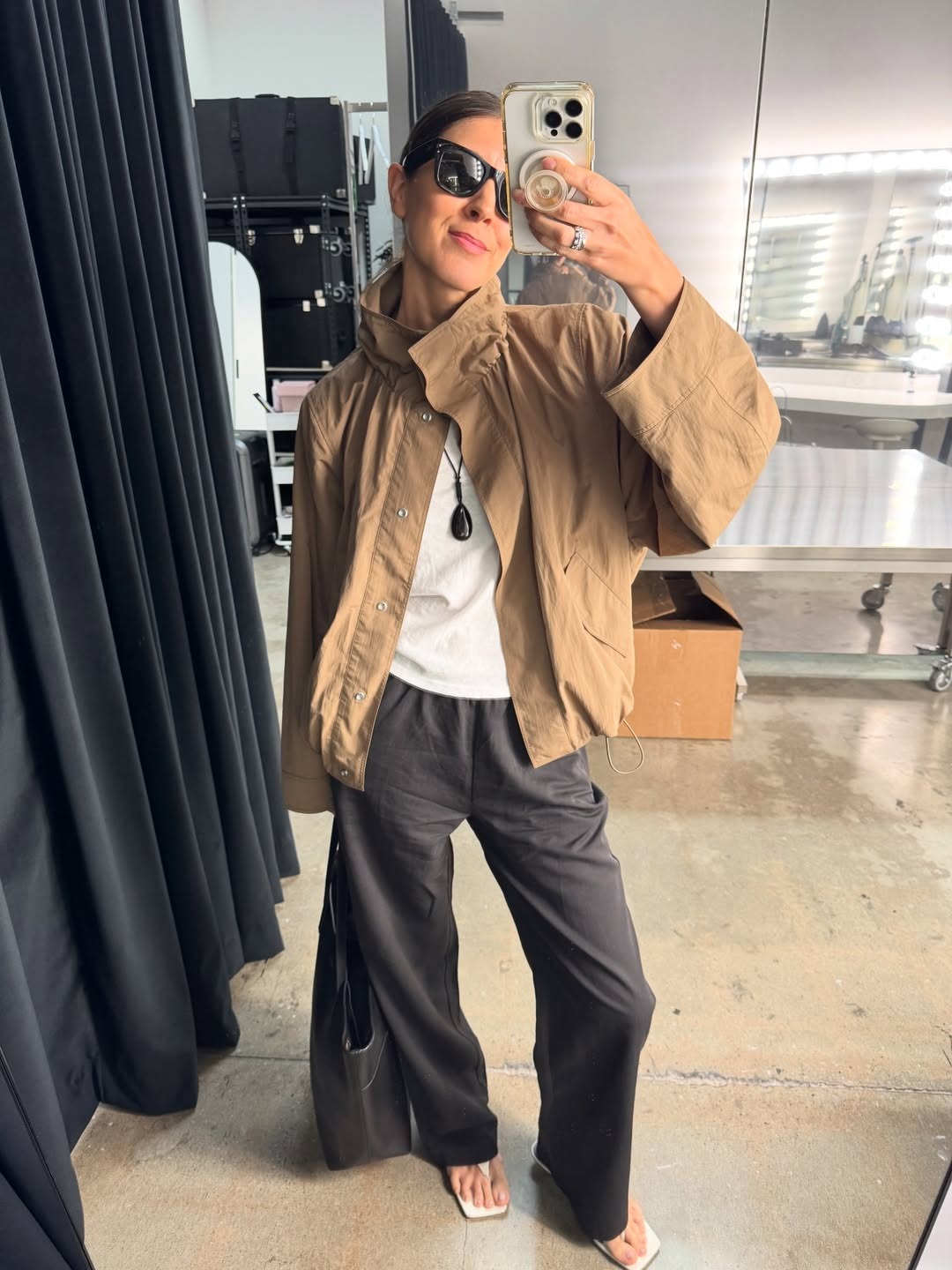 Woman in funnel-neck sporty jacket, white tee, and black pants