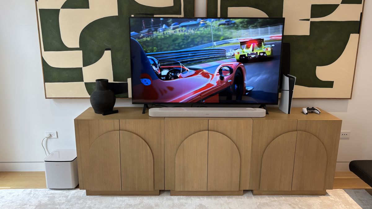 Bose Lifestyle Ultra Soundbar underneath a TV with Subwoofer by its side
