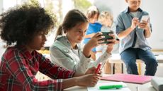 Young kids using smartphones in a classroom setting