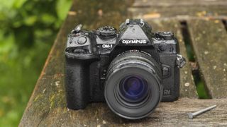 The OM System OM-1 camera on a wooden table