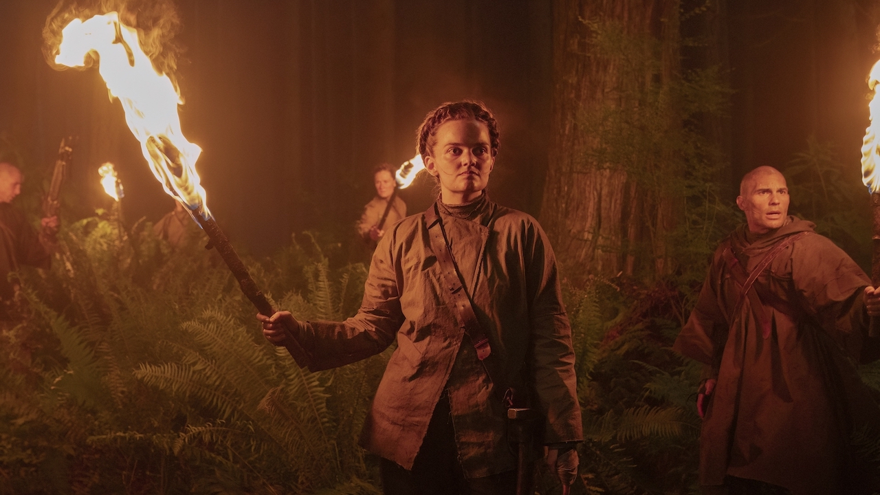 Laine MacNeil as Seraphie holding large torch in the woods in The Last of Us Season 2 Episode 5