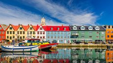 Torshavn harbour, colourful houses and boat on the water.