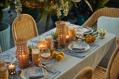 Striped tablecloth, wicker chairs, blue and white table settings