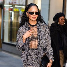 Tessa Thompson wears dipped toe Chanel heels with a tweed skirt suit set and dipped-toe heels.