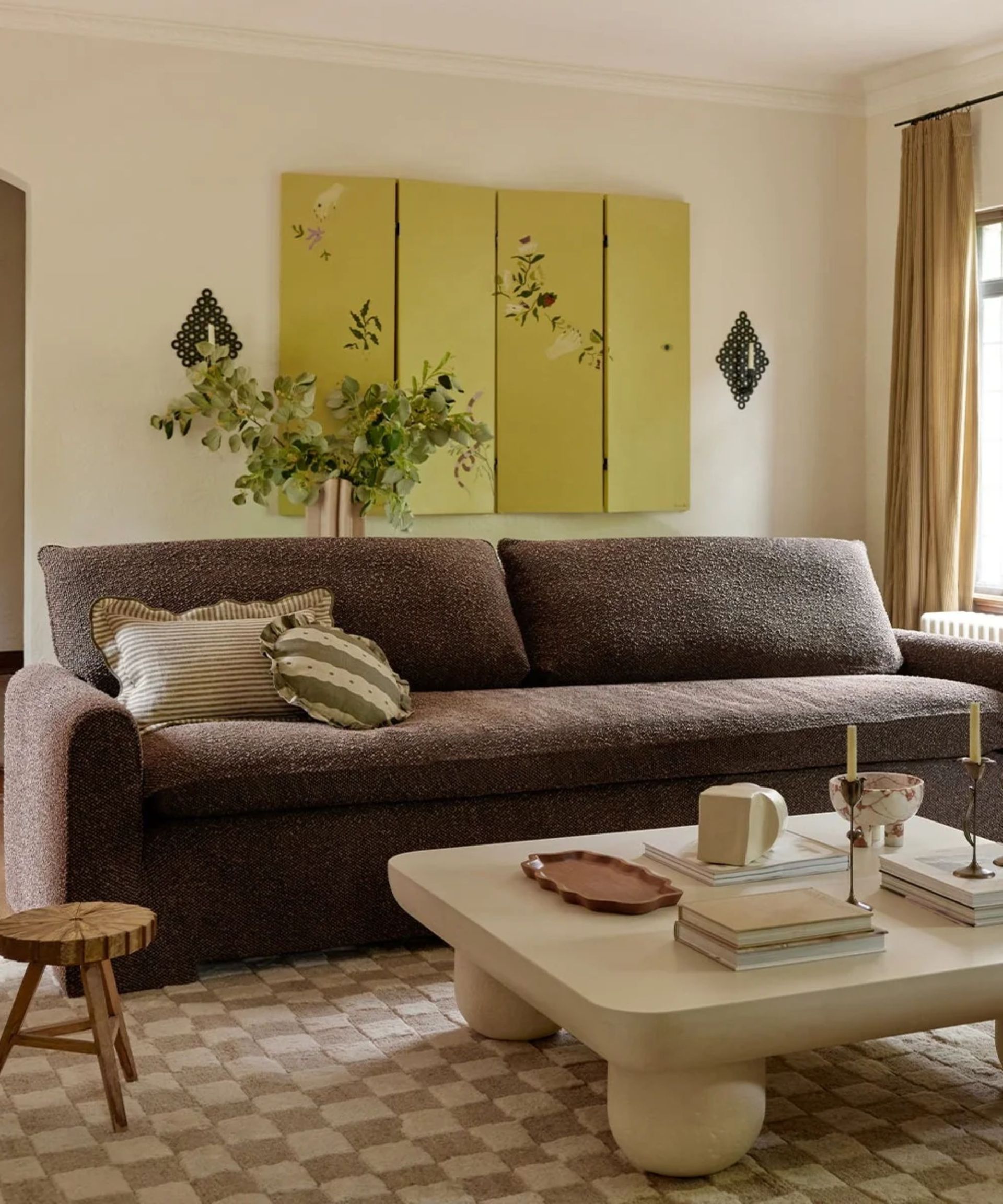 contemporary living room with a chocolate brown boucle couch sat on a checkerboard rug