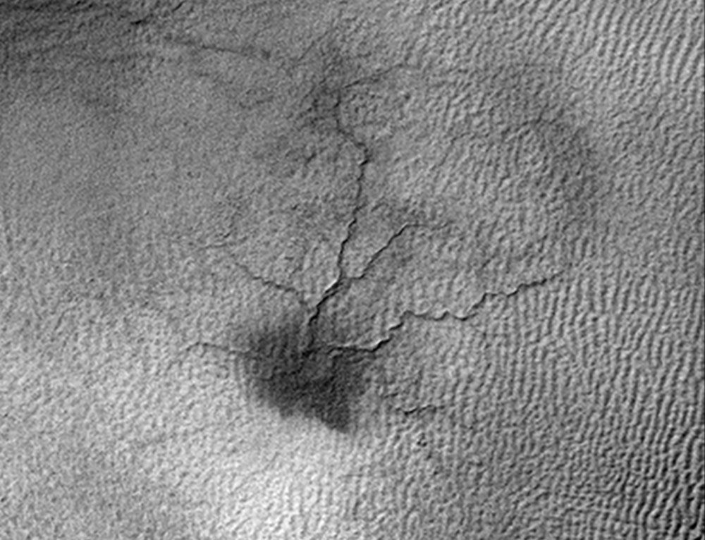 This image by NASA&#039;s Mars Reconnaissance Orbiter shows a network of cracks that may be growing into a larger feature dubbed a &quot;spider.&quot;