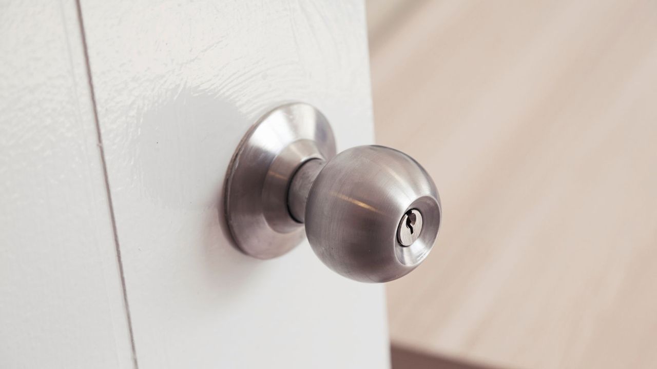 Close up of half opened door knob look through inside the room.