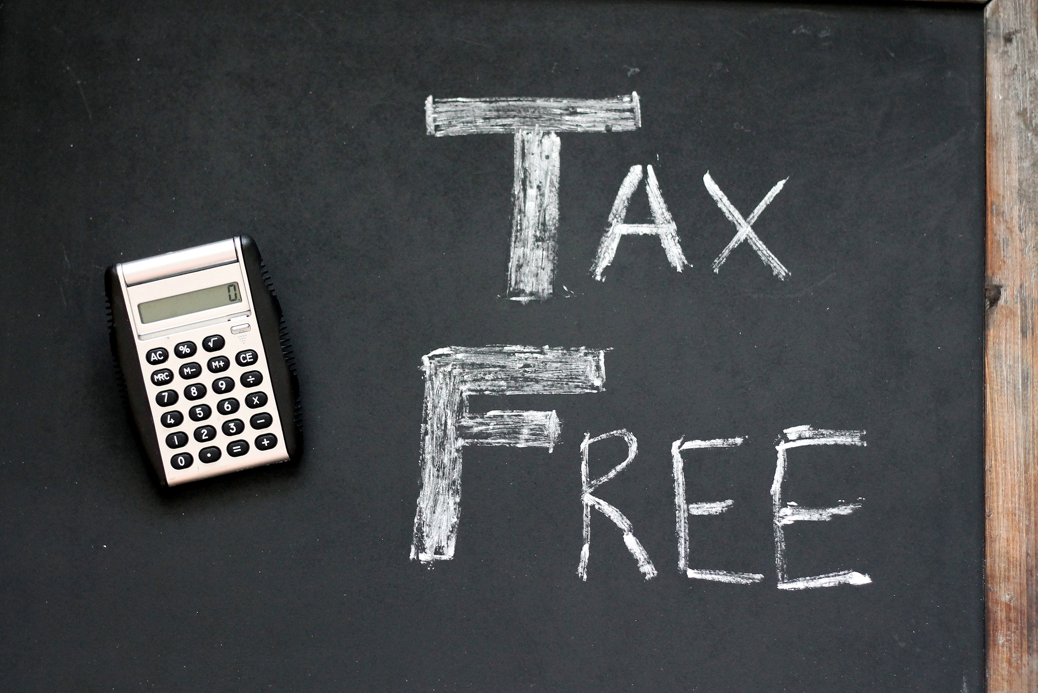 Tax free written on chalkboard next to calculator