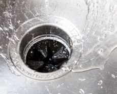 water running through a garbage waste disposal in a sink