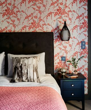 bedroom with orange colour floral printed wall paper and orange bed cover