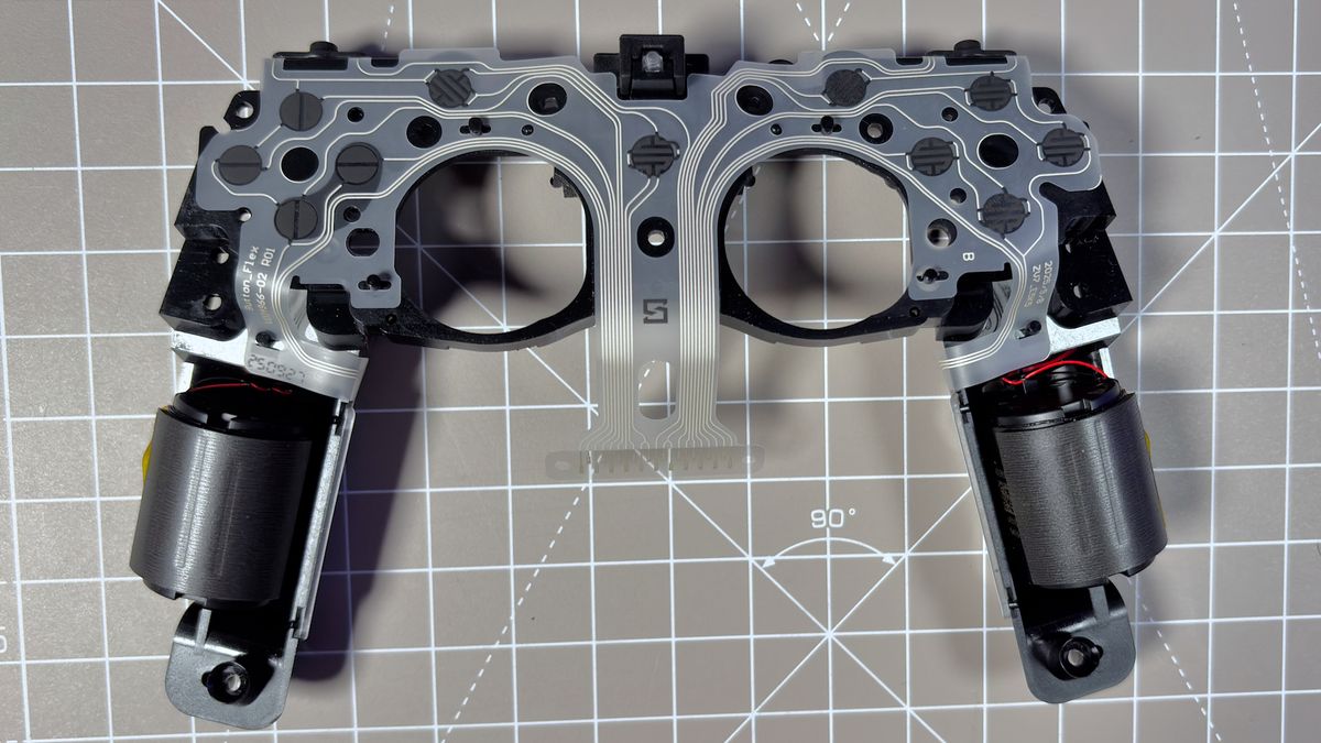The Steam Controller on a desk during a teardown, with various parts removed.