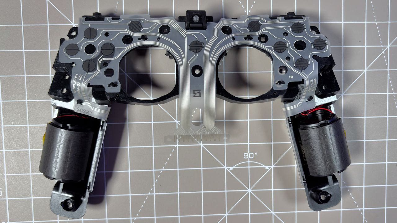 The Steam Controller on a desk during a teardown, with various parts removed.