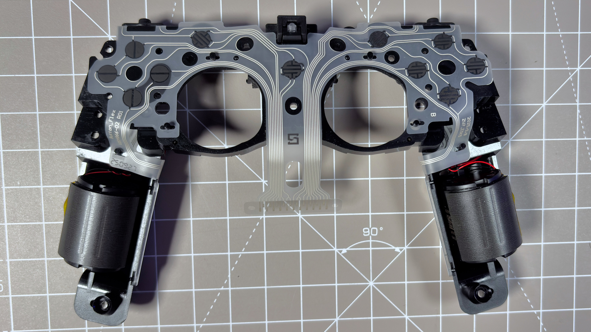 The Steam Controller on a desk during a teardown, with various parts removed.