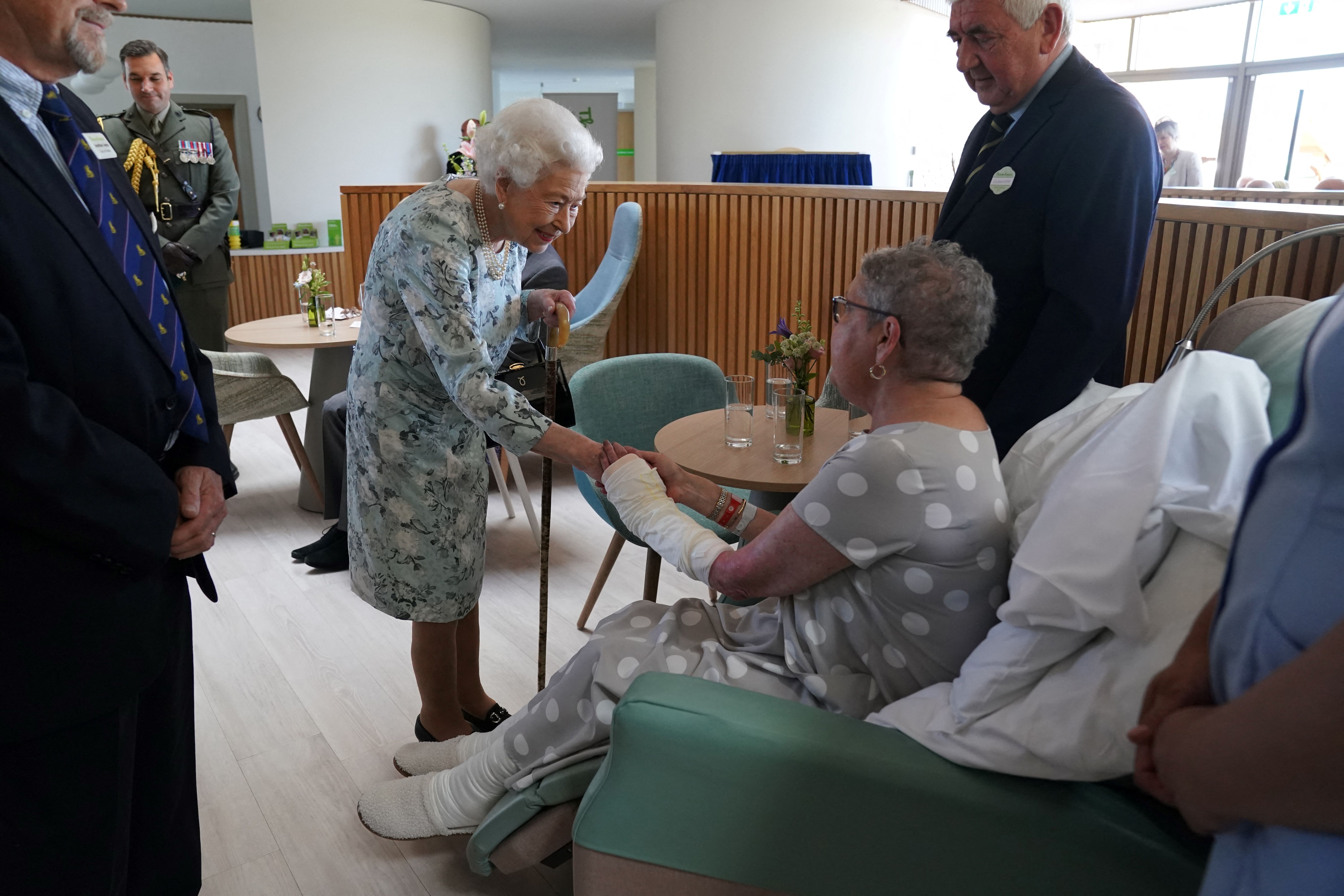 Queen Elizabeth shaking hands with a hospice patient
