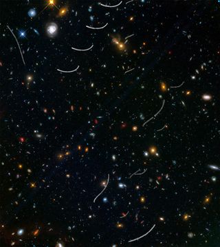 Asteroid trails are visible in this view from the Hubble Space Telescope taken from the Frontier Fields survey, which contains thousands of galaxies. While there are 20 asteroid trails, only seven are unique objects; the remainder are repeats caused by multiple exposures.