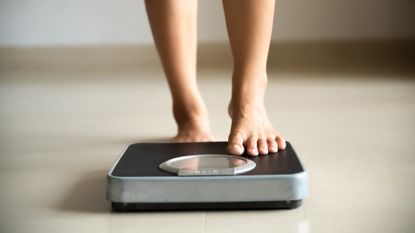 How to lose weight quickly: person stands on some scales