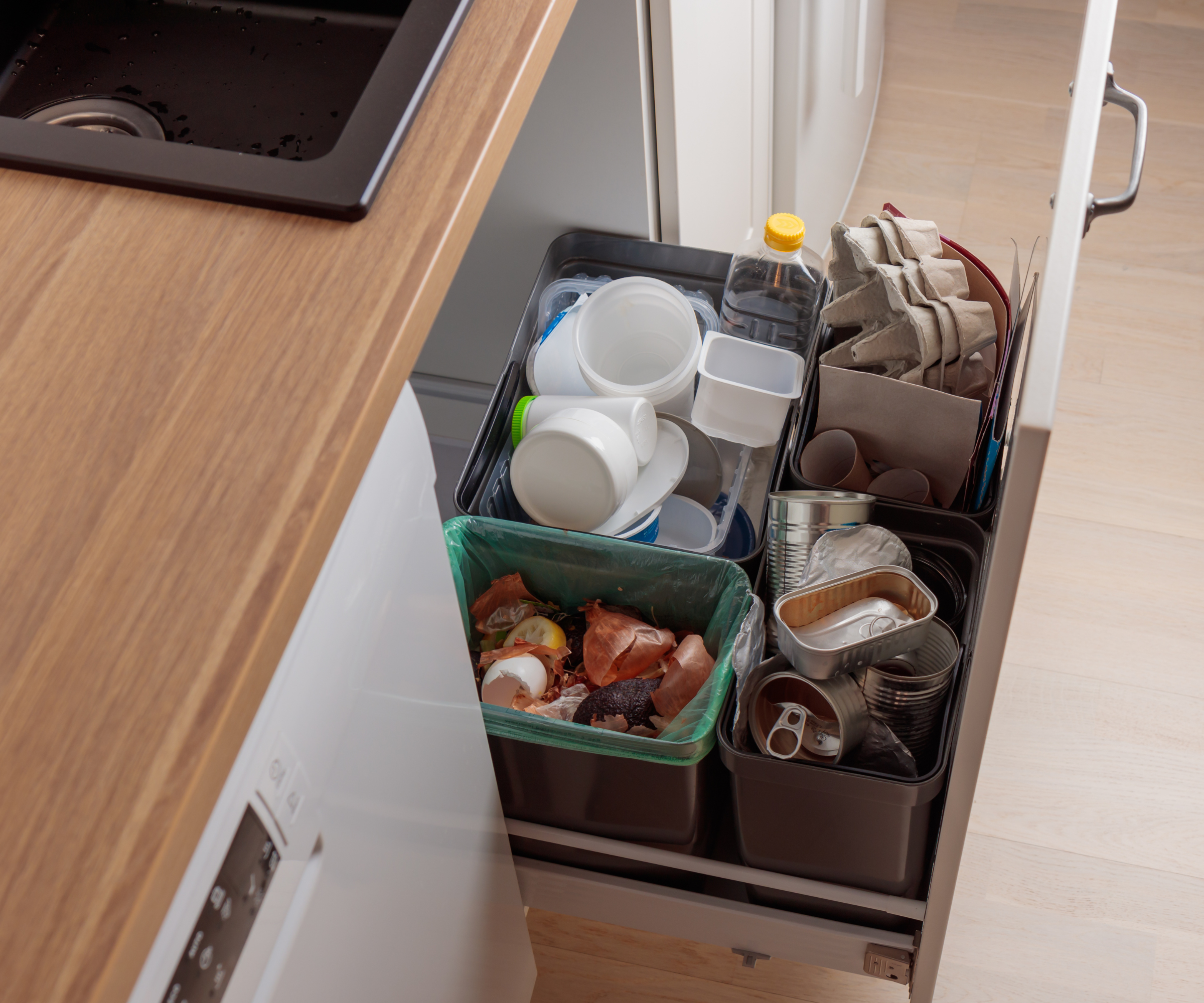 Multiple bins separated inside of a drawer in a kitchen
