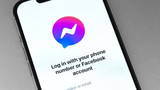 The Facebook Messenger logo on an iPhone screen along with the text 'Log in with your phone number or Facebook account.'